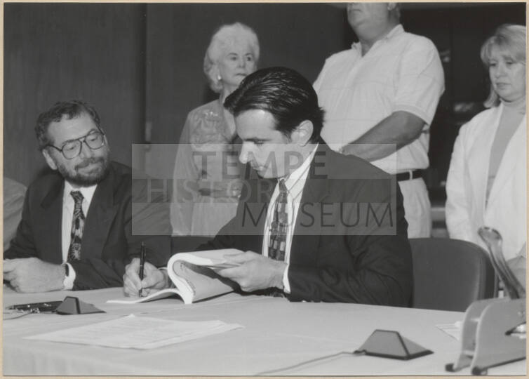 Black and white photograph of Mayor Giuliano signing Town Lake contract
