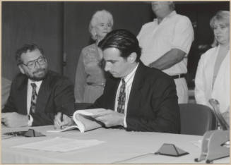 Black and white photograph of Mayor Giuliano signing Town Lake contract