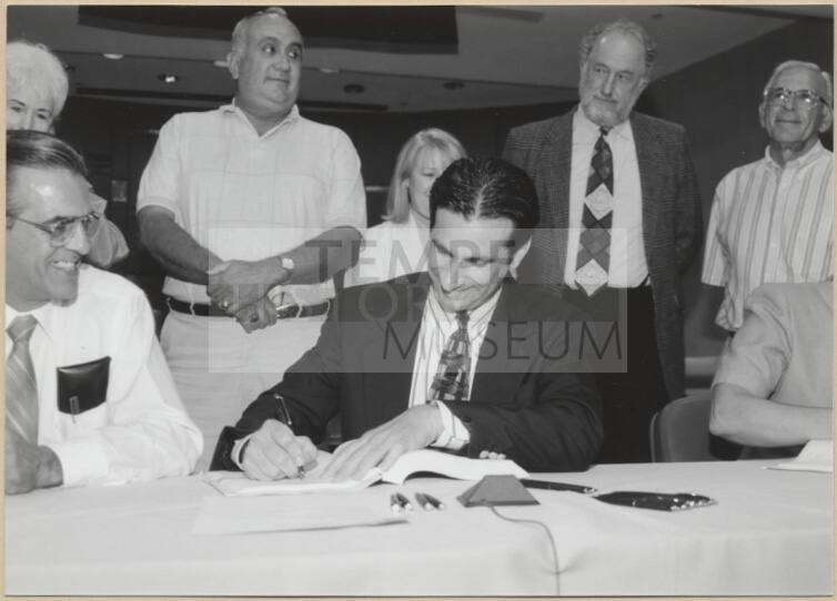 Black and white photograph of Mayor Giuliano signing Town Lake contract
