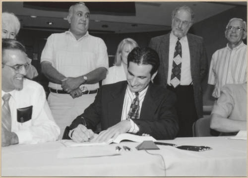 Black and white photograph of Mayor Giuliano signing Town Lake contract