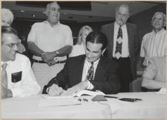 Black and white photograph of Mayor Giuliano signing Town Lake contract