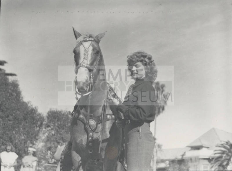 Woman Standing by a Saddled Horse