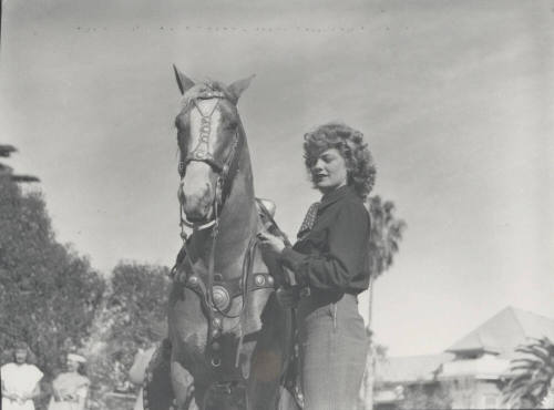 Woman Standing by a Saddled Horse