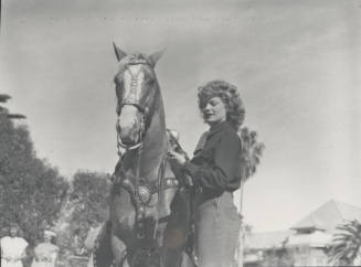Woman Standing by a Saddled Horse