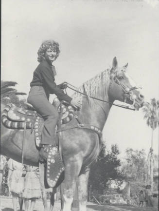 Woman Sitting on a Saddled Horse