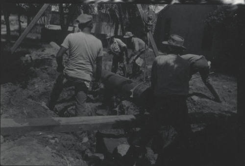Workmen Use Frame + Pulley to Lay Pipe