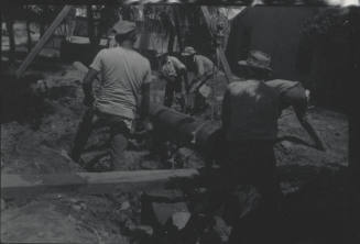 Workmen Use Frame + Pulley to Lay Pipe