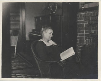 Woman Sitting by Fireplace Reading