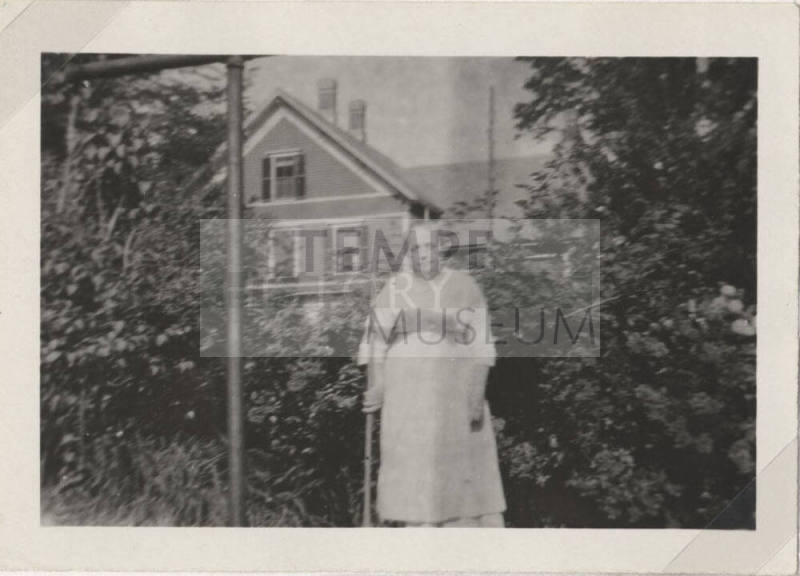 Woman Standing in Front of a House