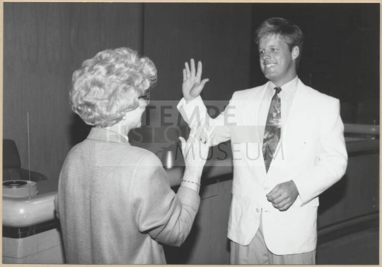 Black and white photograph of city clerk Helen Fowler swearing in council member Joseph Lewis