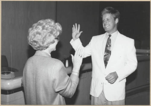Black and white photograph of city clerk Helen Fowler swearing in council member Joseph Lewis