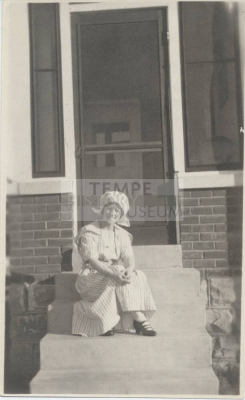 Woman Sitting in Front of House