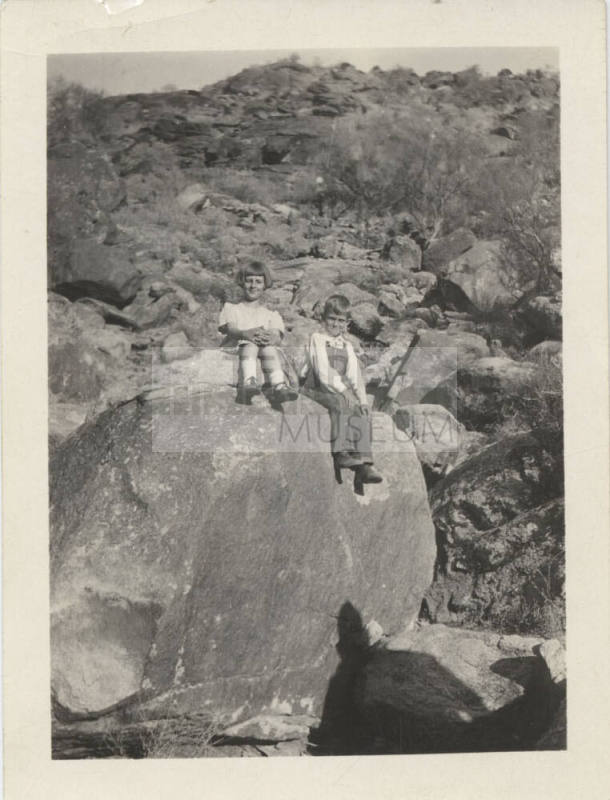 Two Unknown Children Sitting on a Rock
