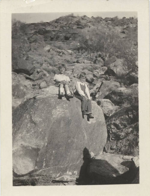 Two Unknown Children Sitting on a Rock