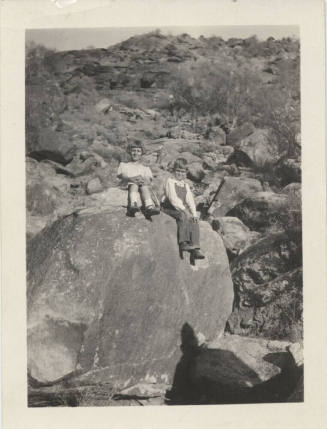 Two Unknown Children Sitting on a Rock