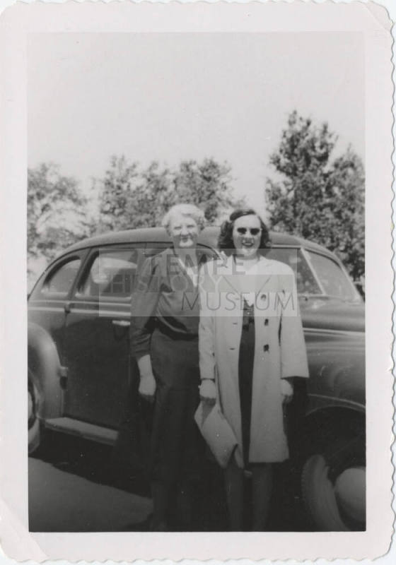 Two Ladies Standing in Front of a Car