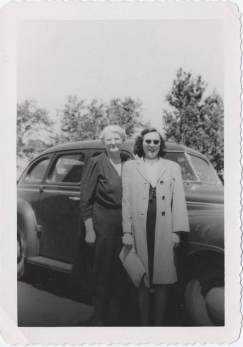 Two Ladies Standing in Front of a Car