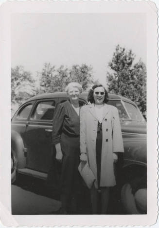 Two Ladies Standing in Front of a Car
