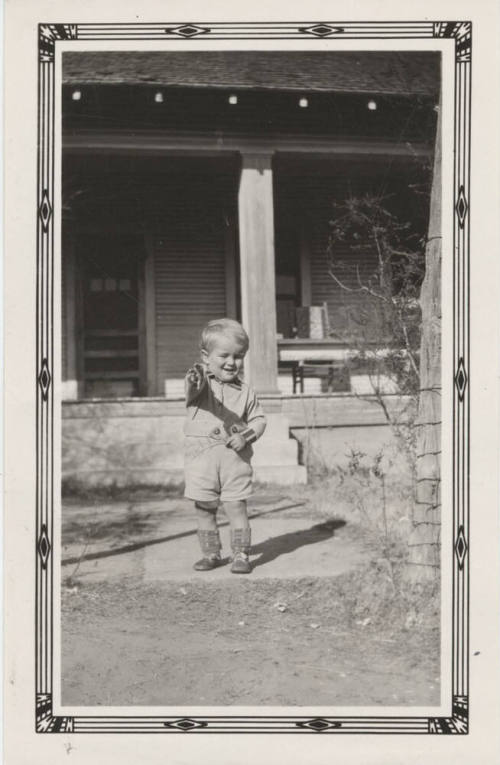 McNeil Boy Standing in Front of a House