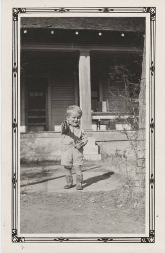 McNeil Boy Standing in Front of a House