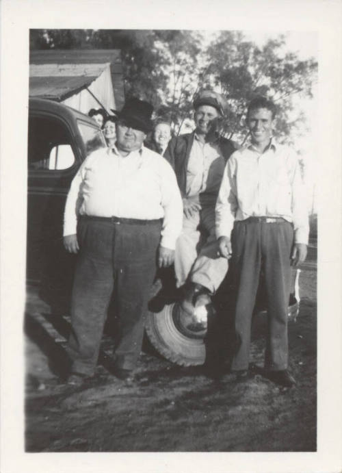 3 Men and 3 Ladies Standing by a Car