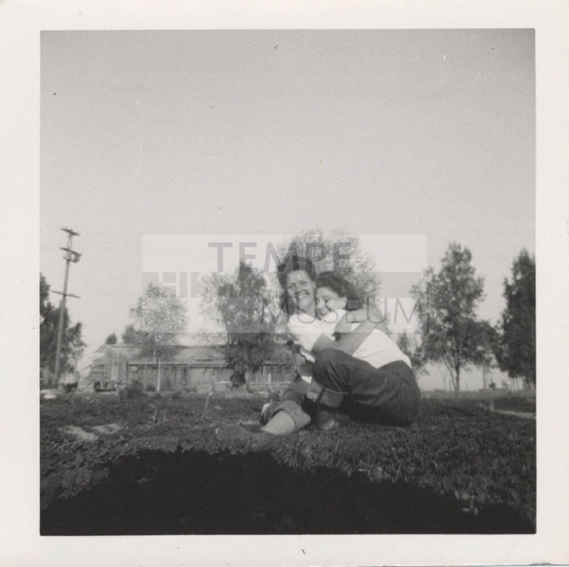 Two Ladies Hugging on a Grass Lawn