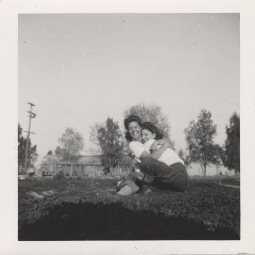 Two Ladies Hugging on a Grass Lawn