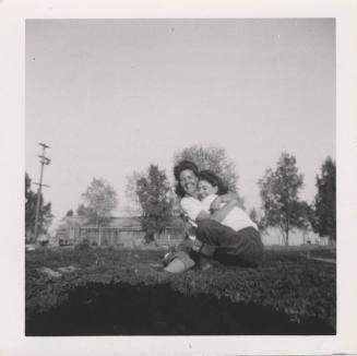 Two Ladies Hugging on a Grass Lawn