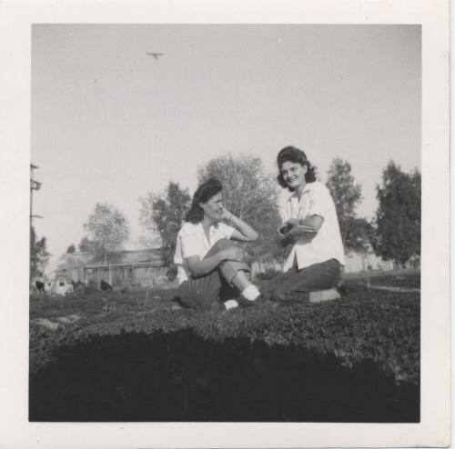 Two Ladies Sitting on a Grass Lawn