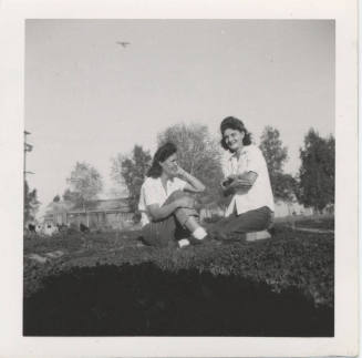 Two Ladies Sitting on a Grass Lawn