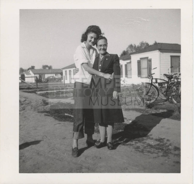 Two Ladies Standing in Front of Homes