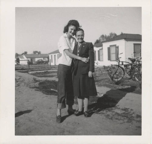 Two Ladies Standing in Front of Homes