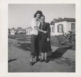 Two Ladies Standing in Front of Homes