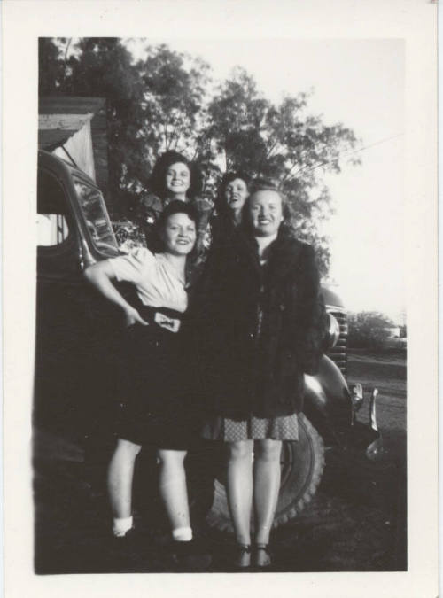 Four Ladies Standing Together by a Car