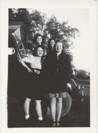 Four Ladies Standing Together by a Car