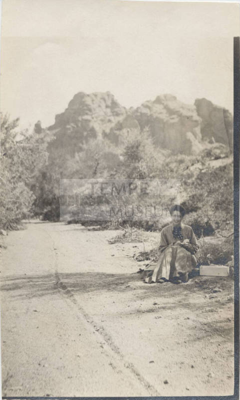 View of a Lady Sitting Next to a Trail