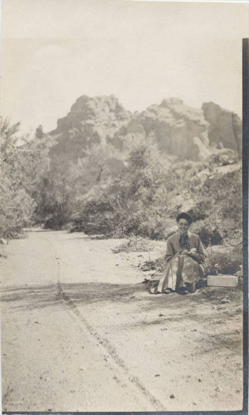 View of a Lady Sitting Next to a Trail