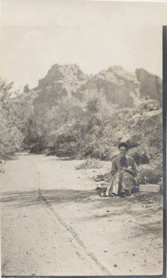 View of a Lady Sitting Next to a Trail