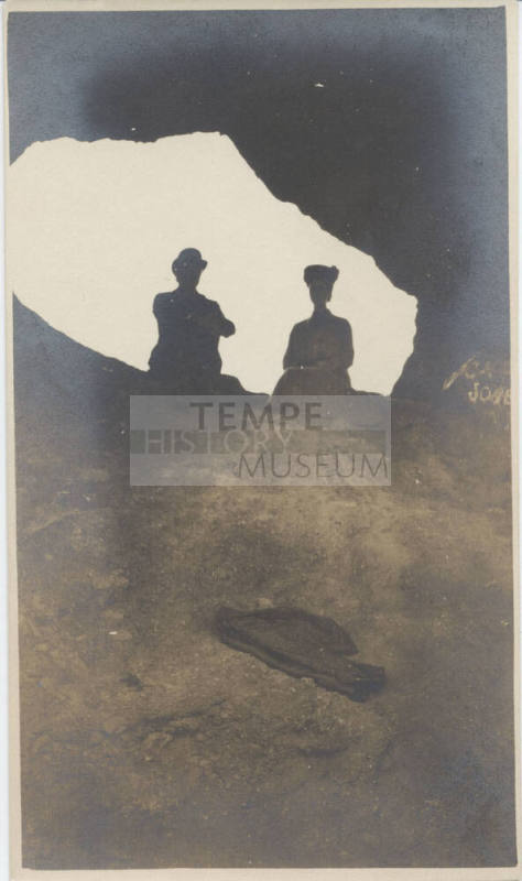 View of People Sitting at Hole in a Rock