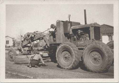 Two men working around road grader