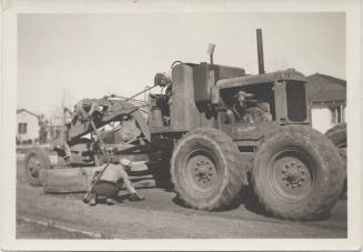 Two men working around road grader
