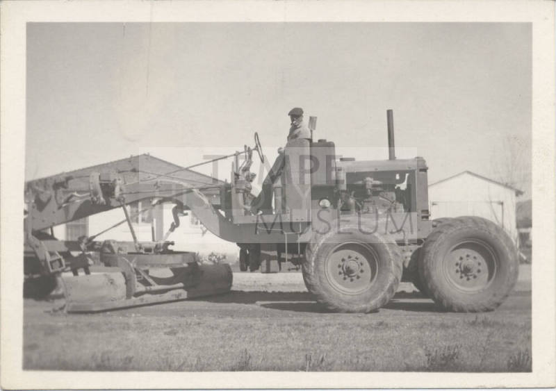 Man Standing on City Road Grader