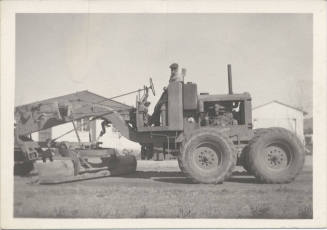Man Standing on City Road Grader