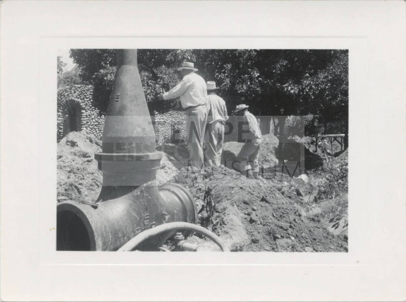 Large Pipe and 3 Men at Construction Site