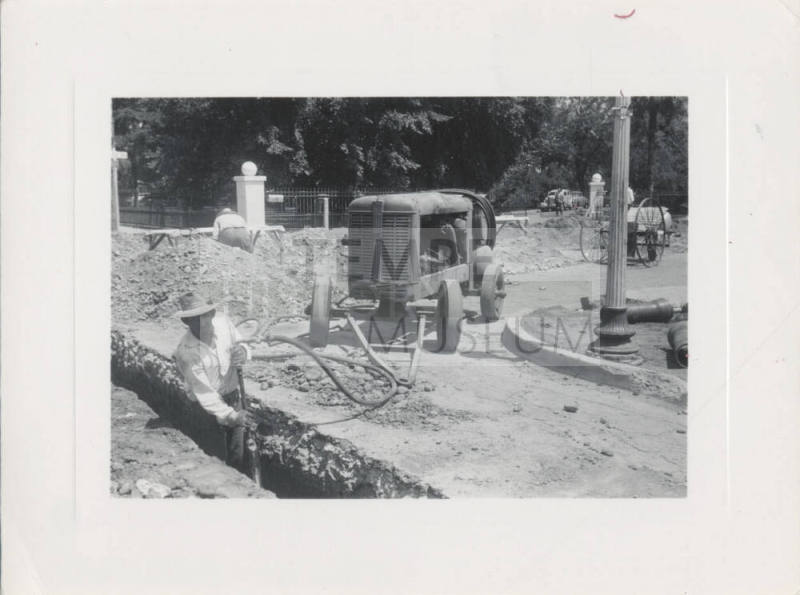 Man Working in Ditch Near Machine