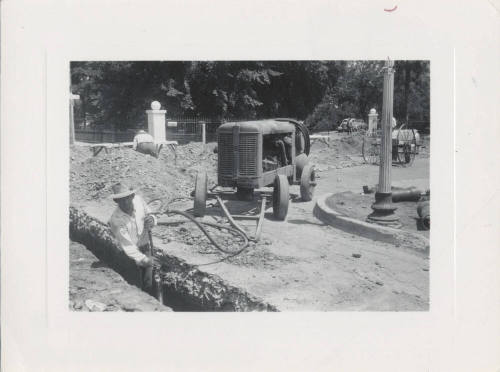 Man Working in Ditch Near Machine