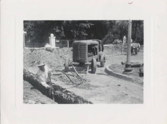 Man Working in Ditch Near Machine