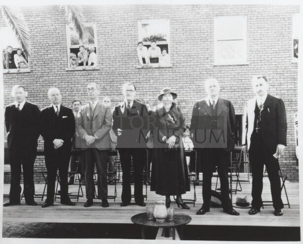 People on a stage as children look on through windows