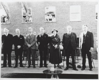 People on a stage as children look on through windows