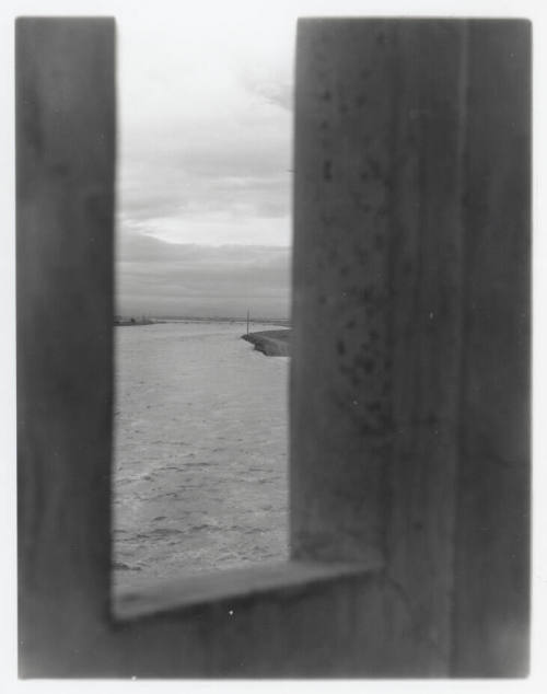 Vertical shot of river through opening in bridge (?)